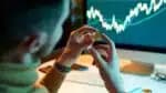 The man checks and controls the financial database on international exchanges holding gold bitcoins. Crypto trader investor analyst looks at laptop screen, analyzes financial chart data