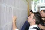 PORTO ALEGRE, RS, VESTIBULAR-RS - Vestibulandos conferem e comemoram a lista de aprovados no vestibular 2015 da Universidade Federal do Rio Grande do Sul (UFRGS), divulgada na manhã desta sexta-feira (16). A lista com os nomes dos 3.996 selecionados foi afixada no mural do prédio anexo da Reitoria, no Campus Central, em Porto Alegre (RS). (Foto: Cau Guebo/Raw Image/Folhapress)